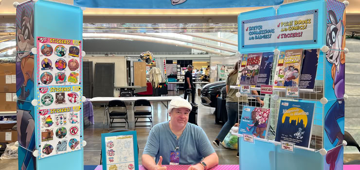 Artist at his table at Anthrocon '25